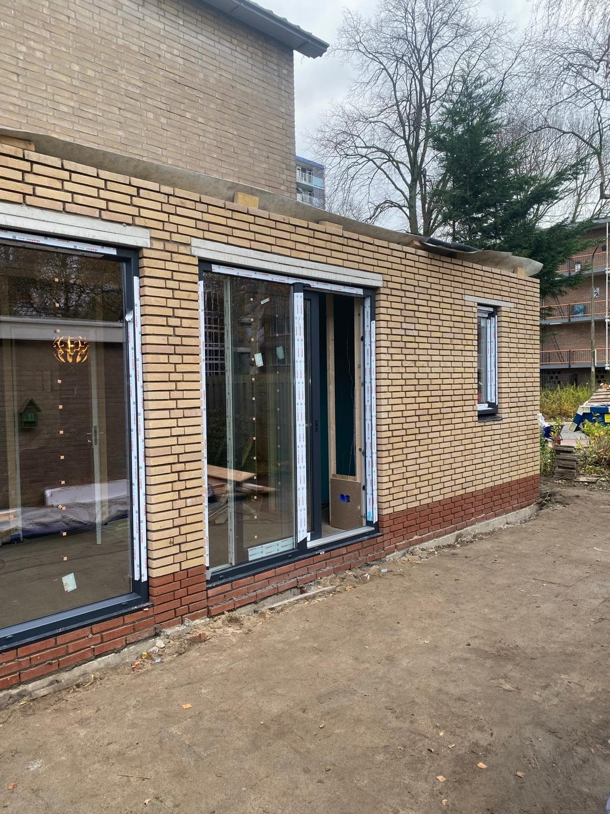 Aanbouw met nieuw metselwerk en grote kozijnen aan de achterzijde van een woning